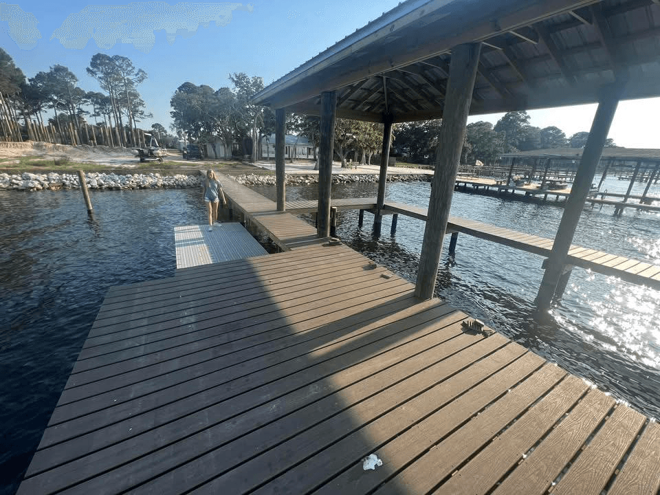 Wide overhead view of a custom dock and covered boat slip on Pensacola Bay